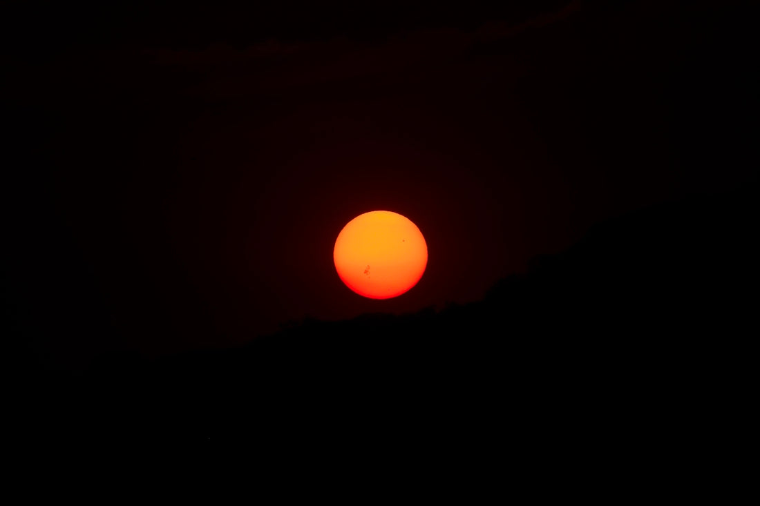 the sun is setting in the dark sky