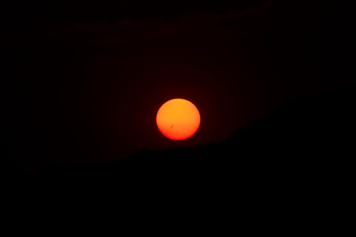 the sun is setting in the dark sky