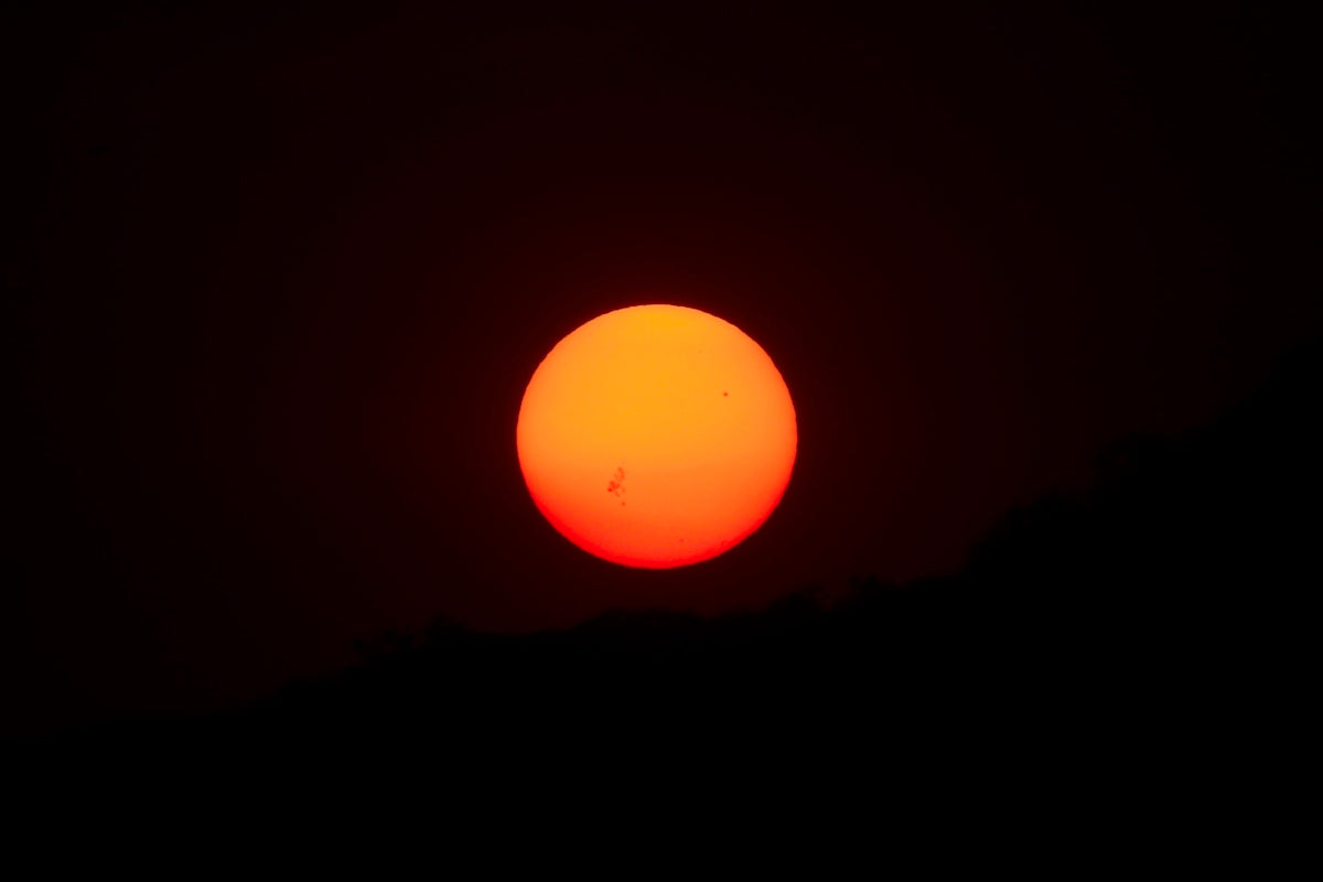 the sun is setting in the dark sky