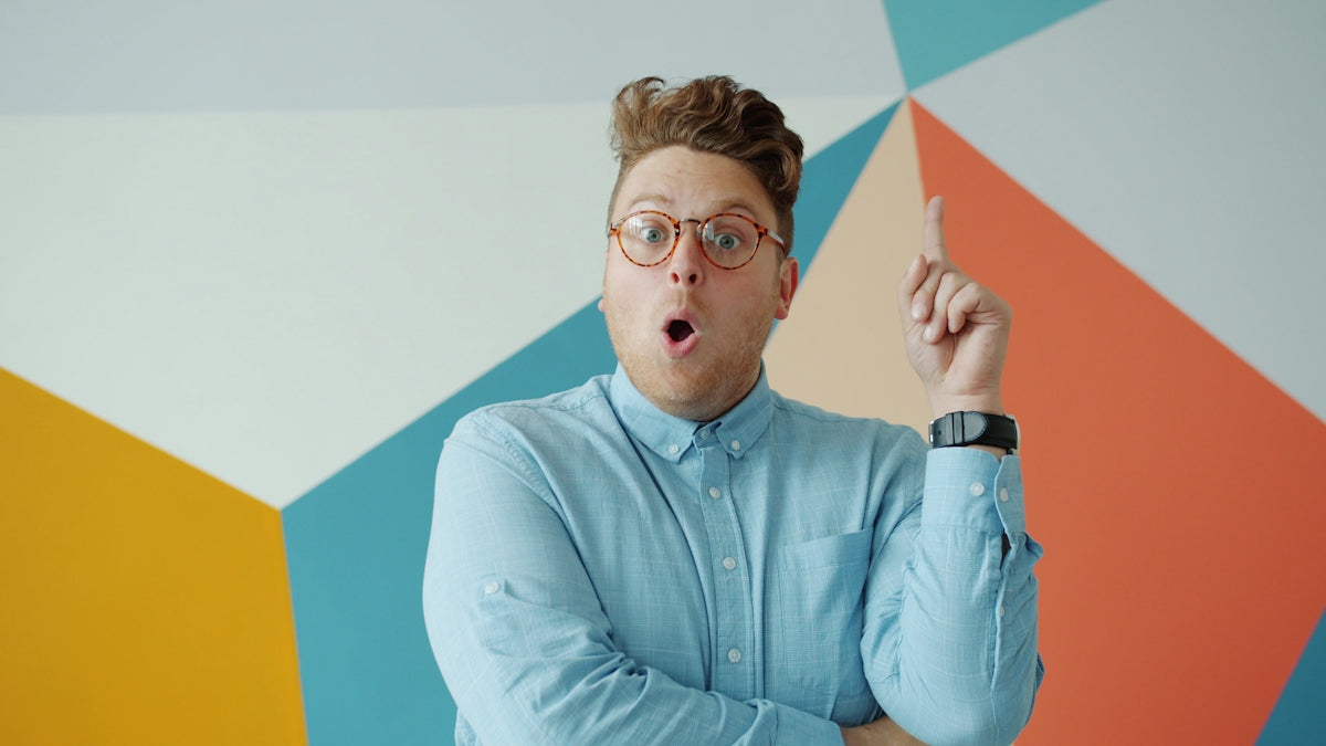 Man with glasses makes surprised expression with idea
