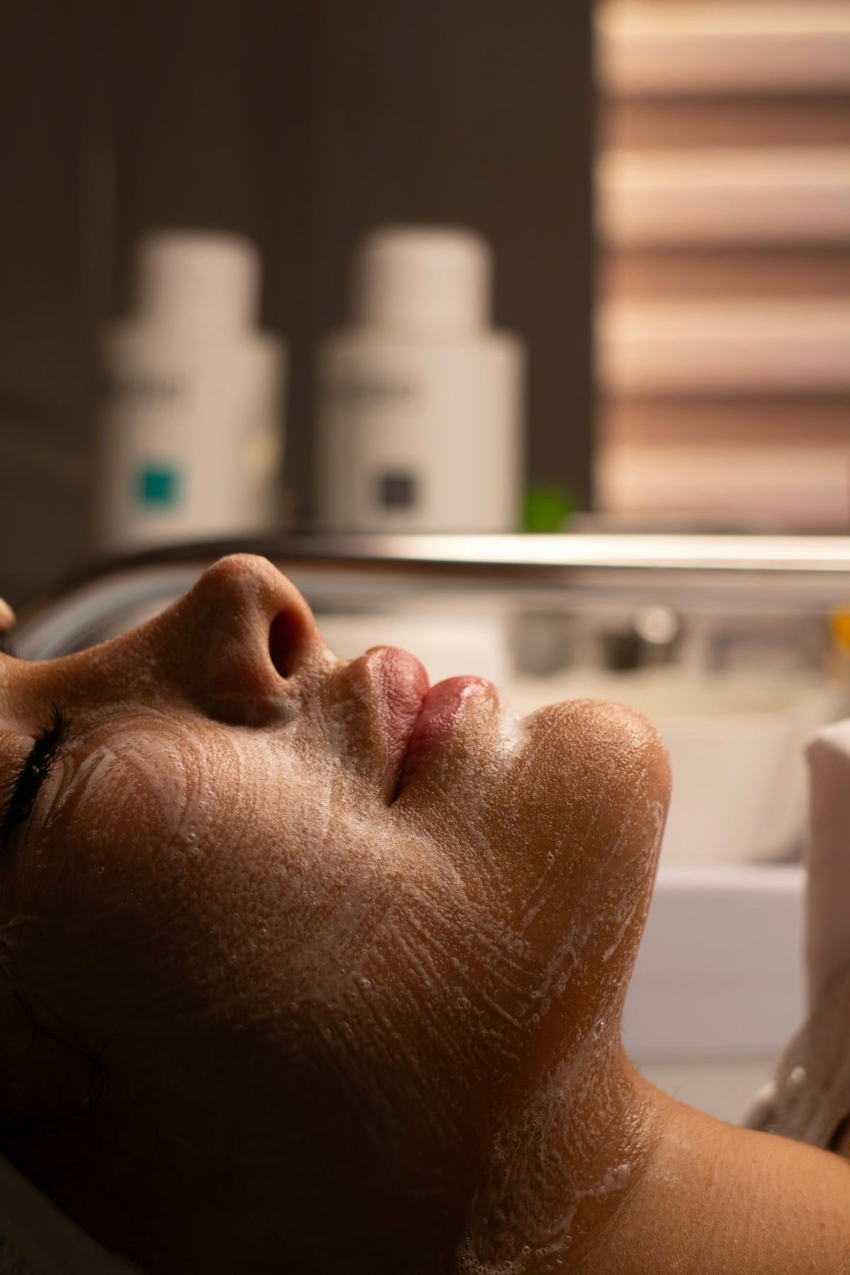 Woman's face with cleansing foam during facial treatment